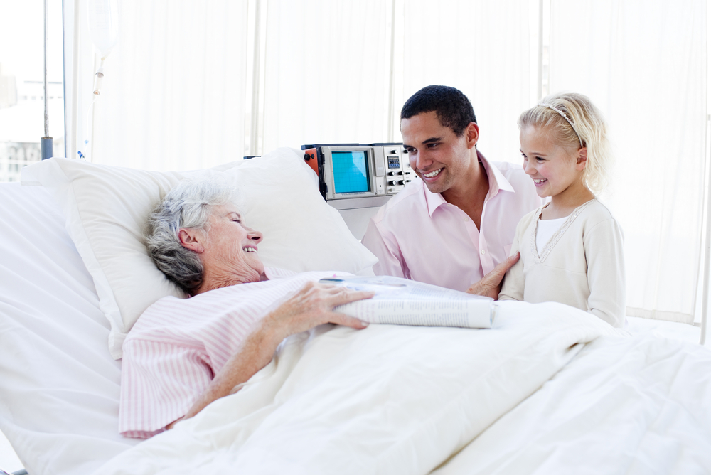 Adorable little girl with her father visiting her grandmother at the hospital