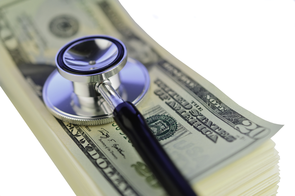 Examination of financial condition Stethoscope on pile of U.S. twenty-dollar bills isolated on white background-1