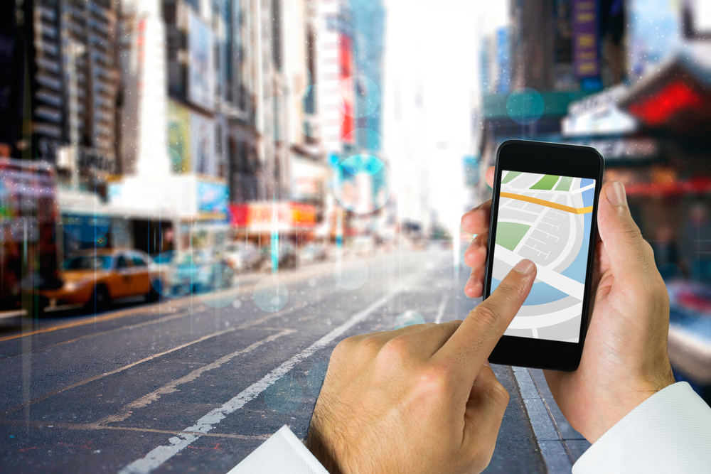 Man using map app on phone against blurry new york street